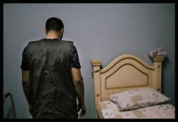 A young man wearing an improvised protection vest made from the plastic from Coke bottles. The vest helps protect from bird shot. Manama, Bahrain, 2013.